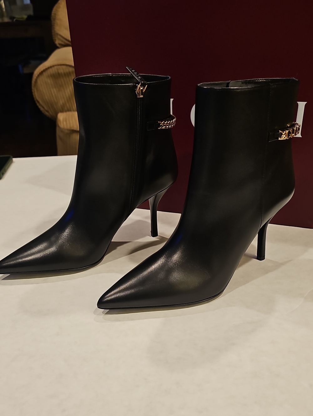 Gucci Black Pointed-Toe Leather Ankle Boots with Gold Chain Accent